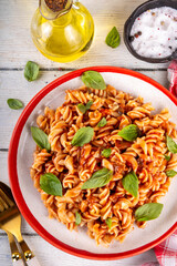 Fusilli pasta with bolognese sauce, with ground beef, mushrooms, tomatoes and basil. Traditional Italian lunch pasta plate, with spices served on the table copy space