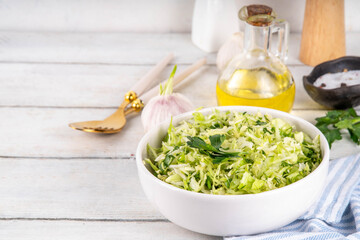 Spring cabbage salad, vegan healthy diet vegetable food, salad with spring cabbage, parsley, green onions, olive oil for dressing