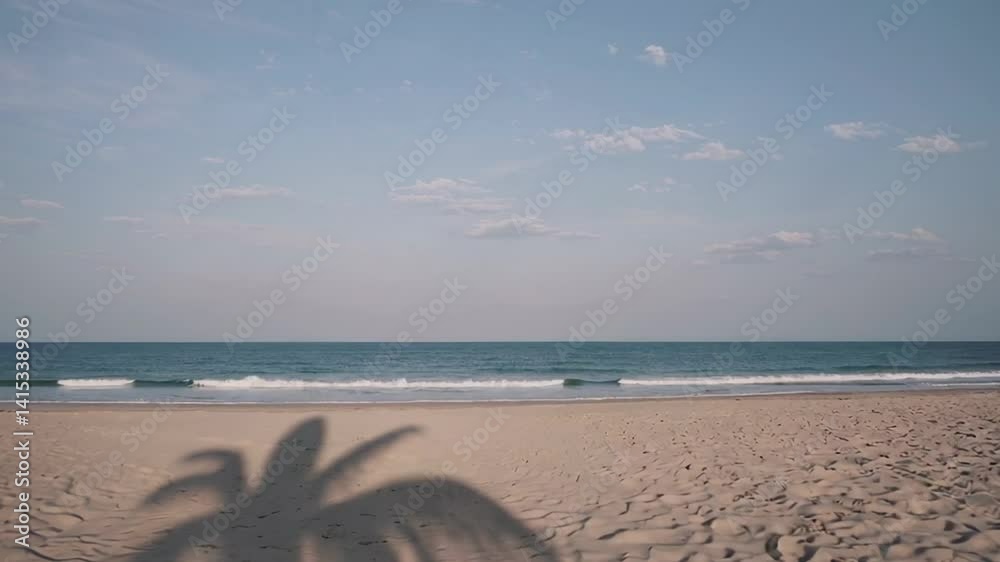 Poster gentle waves lap the shore of a serene beach, while the shadow of a palm tree graces the sand, creat