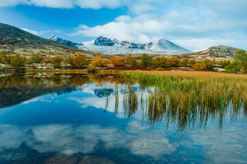 Reflections of Rondane National Park highlight serene landscapes and autumn colors in Norway