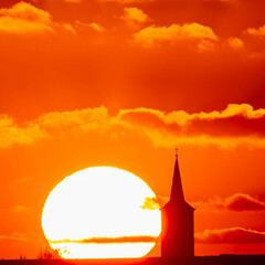 Megazoom (600mm) winter sunset or sundowner with a church silhouette near Haunersdorf, Otzing, Deggendorf, Bavaria, Germany
