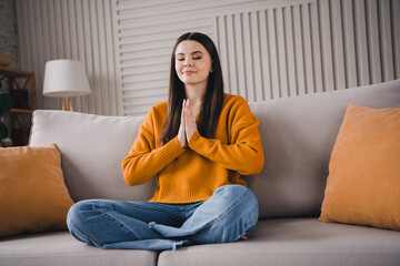 Obraz premium Young calm woman practicing mindfulness at home in a cozy interior setting