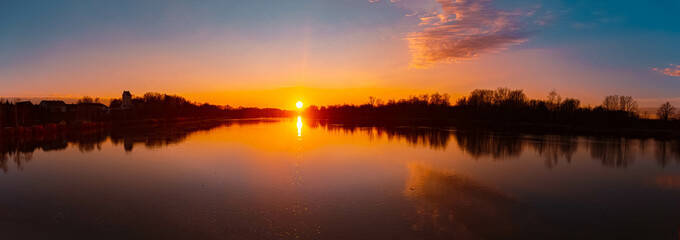 High resolution stitched winter sunset or sundowner panorama with reflections near Niederpoering,...