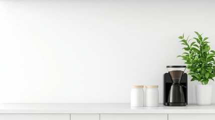Modern kitchen countertop featuring a coffee maker, jars, and a potted plant against a white wall