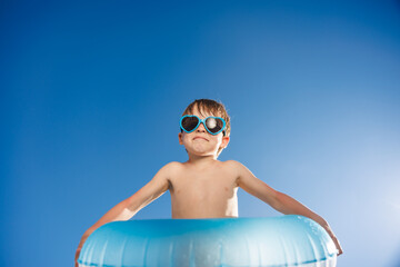 Happy child playing in waterpark. Kid having fun on summer vacation
