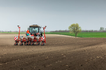 Fototapeta premium Tractor and seeder for sowing corn
