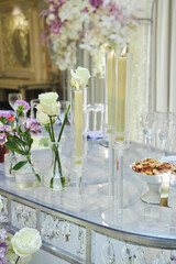 The decor for the celebration. Flower decoration. Close-up of a bouquet and candles