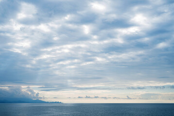 Sea blue cloudy evening landscape. Black sea, sky, mountains and Batumi city in Georgia visible on horizon