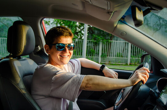 Smiling Woman Driving Car in Sunglasses - Powered by Adobe