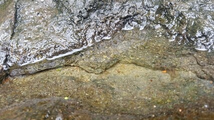 View of puddles of rainwater turning into rivers on the rocks 