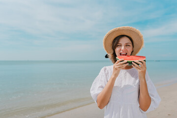 woman smiling and eating watermelon on the beach at sunset. woman eating watermelon watermelon cocktail on a tropical beach