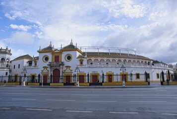 Seville, Spain - Mar 23, 2025: Walking in Seville. Plaza de Toros de la Maestranza. Streets, buildings. Lifestyle in the urban area. Cloudy spring day. Selective focus