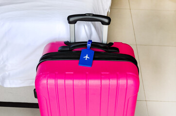 Bright Pink Suitcase in Hotel Room Interior