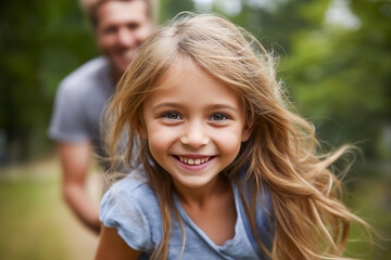 Joyful girl plays outdoors with father, capturing a moment of fun and connection in nature