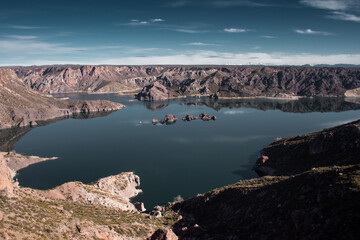 Landscape photographs of arid lakes with snow-capped mountains in the background.