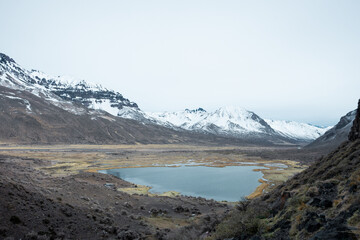 Woman on vacation in a cave with a lagoon in the background.