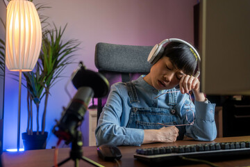 A beautiful Japanese gamer experiencing vision problems during a stream, with neon lights in the background.
