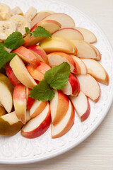 A plate of season cut fresh apple, pear and banana. Diet, healthy fruit salad on plate - healthy breakfast, weight loss concept. Directly above