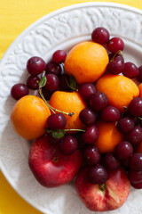 A plate of season cut fresh fruit and berries. Fruit salad. Diet, healthy fruit salad on plate - healthy breakfast, weight loss concept.