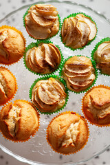 Top view on homemade vanilla muffins with sliced apple on on the glass plate. Healthy food, snack. Selective focus