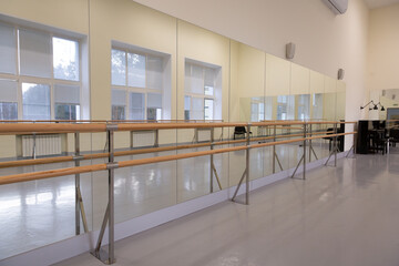 Indoor ballet class room with mirrors, a piano and training dance ballet bar for stretching