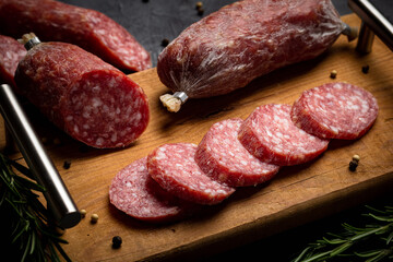 Chopping board with sliced salami. Italian sausage. Close up