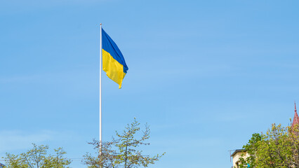 Ukrainian flag waving on clear blue sky symbolizing unity and pride
