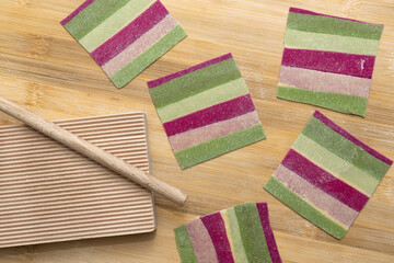 Trozos de pasta fresca de colores, para elaborar garganelli con utensilios italianos para su confecci&oacute;n.