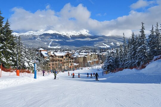 The view of the town and ski slopes in Whistler, with snow on them, snow-covered trees and mountains