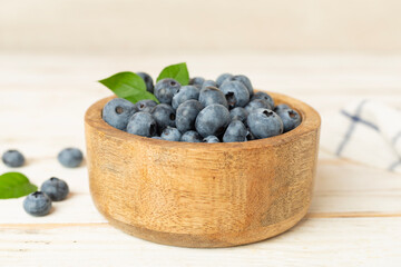 Bowl with fresh blueberries on wooden table