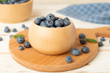 Bowl with fresh blueberries on wooden table