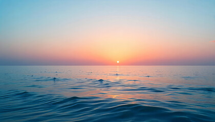 Obraz premium A sunset over the ocean with a gradient of colors in the sky, from blue to pink to orange, and the sun reflecting on the water
