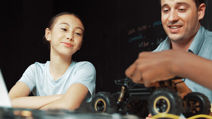 Caucasian girl looking at car model at blackboard with engineering prompt and code. Smart...
