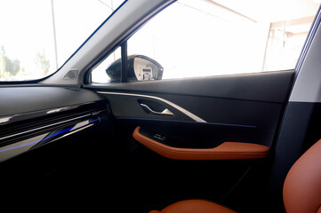 Interior view of a car showcasing brown leather seats with black seat belts.