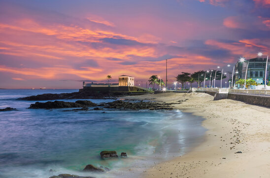 Sunset over Porto da Barra Beach,Salvador Bahia Brazil with calm waves and historic fort