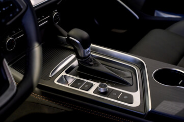 Selector automatic transmission with leather in the interior of a modern expensive car. The background is blurred.