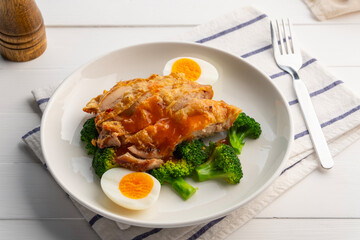 Healthy Diet High Protein Low Fat,zero oil Air fryer Grilled Chicken thighs with boiled egg and broccoli in white plate.It's crispy on skin and soft on the inside.