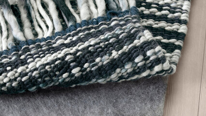 Textured wool textile showcasing intricate weaving patterns in dark and light tones.