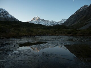 Partly frozen lake mirror pond reflection tarn view of Mount Cook Aoraki from the Hooker Valley,...