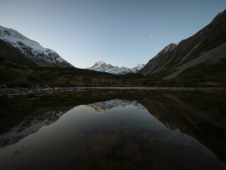 Partly frozen lake mirror pond reflection tarn view of Mount Cook Aoraki from the Hooker Valley,...