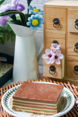 A traditional Indonesian steamed layer cake with alternating vibrant layers, showcasing a soft,...