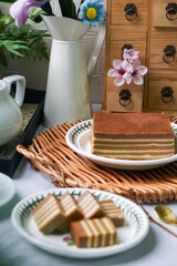 A traditional Indonesian steamed layer cake with alternating vibrant layers, showcasing a soft,...