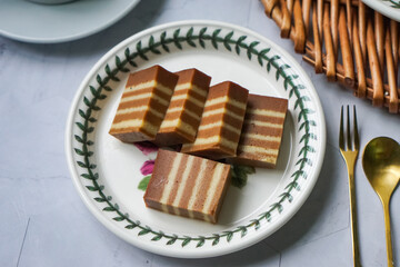 A traditional steamed layer cake with alternating vibrant layers, showcasing a soft, moist texture...