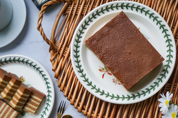 A traditional steamed layer cake with alternating vibrant layers, showcasing a soft, moist texture and rich flavors, perfect for festive occasions.