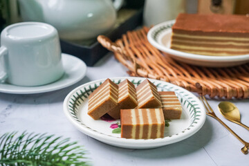 A traditional Indonesian steamed layer cake with alternating vibrant layers, showcasing a soft, moist texture and rich flavors, perfect for festive occasions.