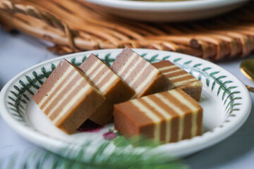 A traditional Indonesian steamed layer cake with alternating vibrant layers, showcasing a soft, moist texture and rich flavors, perfect for festive occasions.