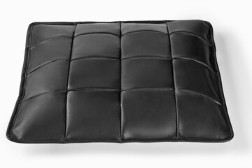 Black leather cushion resting on white background