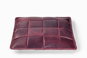 Burgundy leather cushion floating on white background: modern home decor