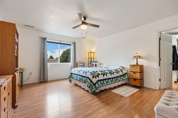 A cozy bedroom with a stylish four poster bed, chair, and lamp