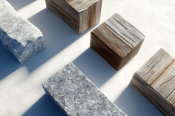 Natural materials arranged on a snow-covered surface showcasing wood and stone blocks in winter lighting